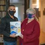 Two people holding Golden Heights Book